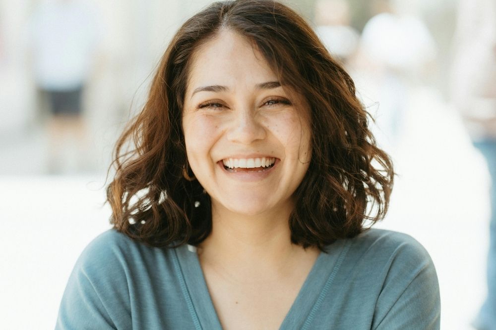 Woman smiling confidently after cosmetic dentistry treatment at SmileHQ in Essex