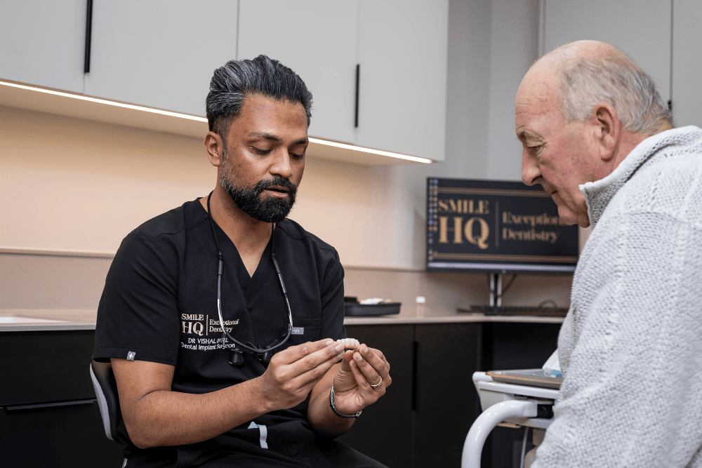 Dr Vishal Patel discussing full-arch dental implant treatment with a patient at SmileHQ
