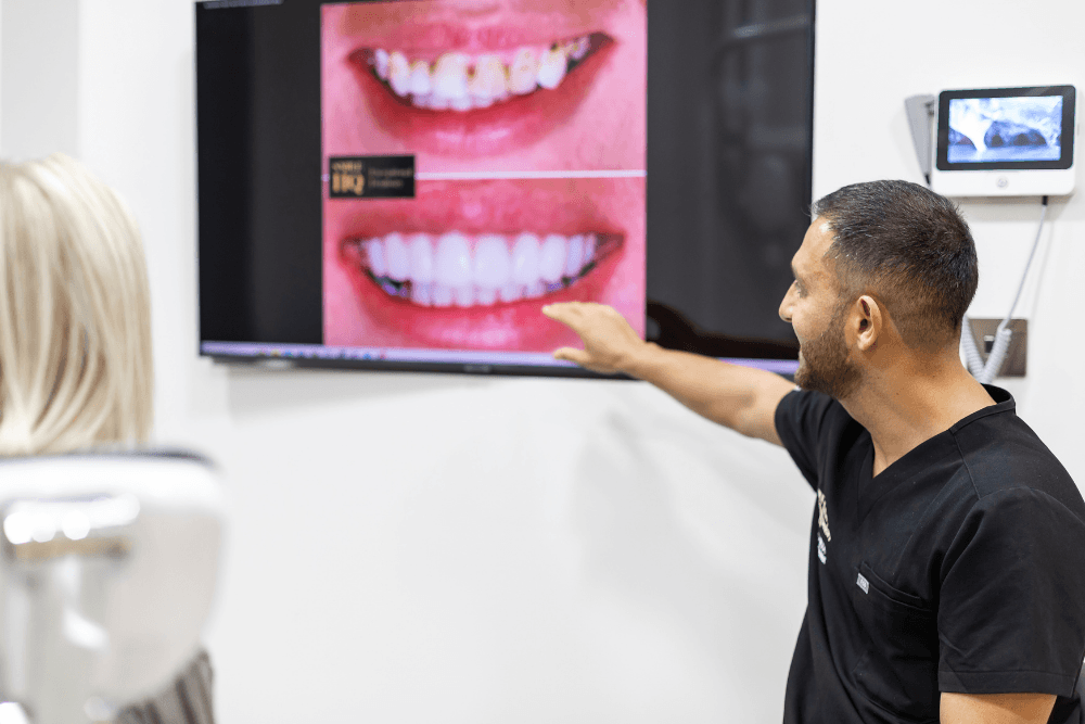 Cosmetic dentist Pola Reza discussing before and after smile photographs with a patient at SmileHQ